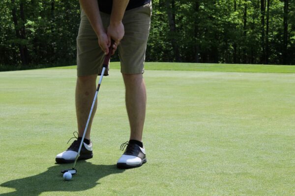 Golf club fitter comparing iron shaft options for a golfer using TrackMan data at a Chicagoland fitting session.